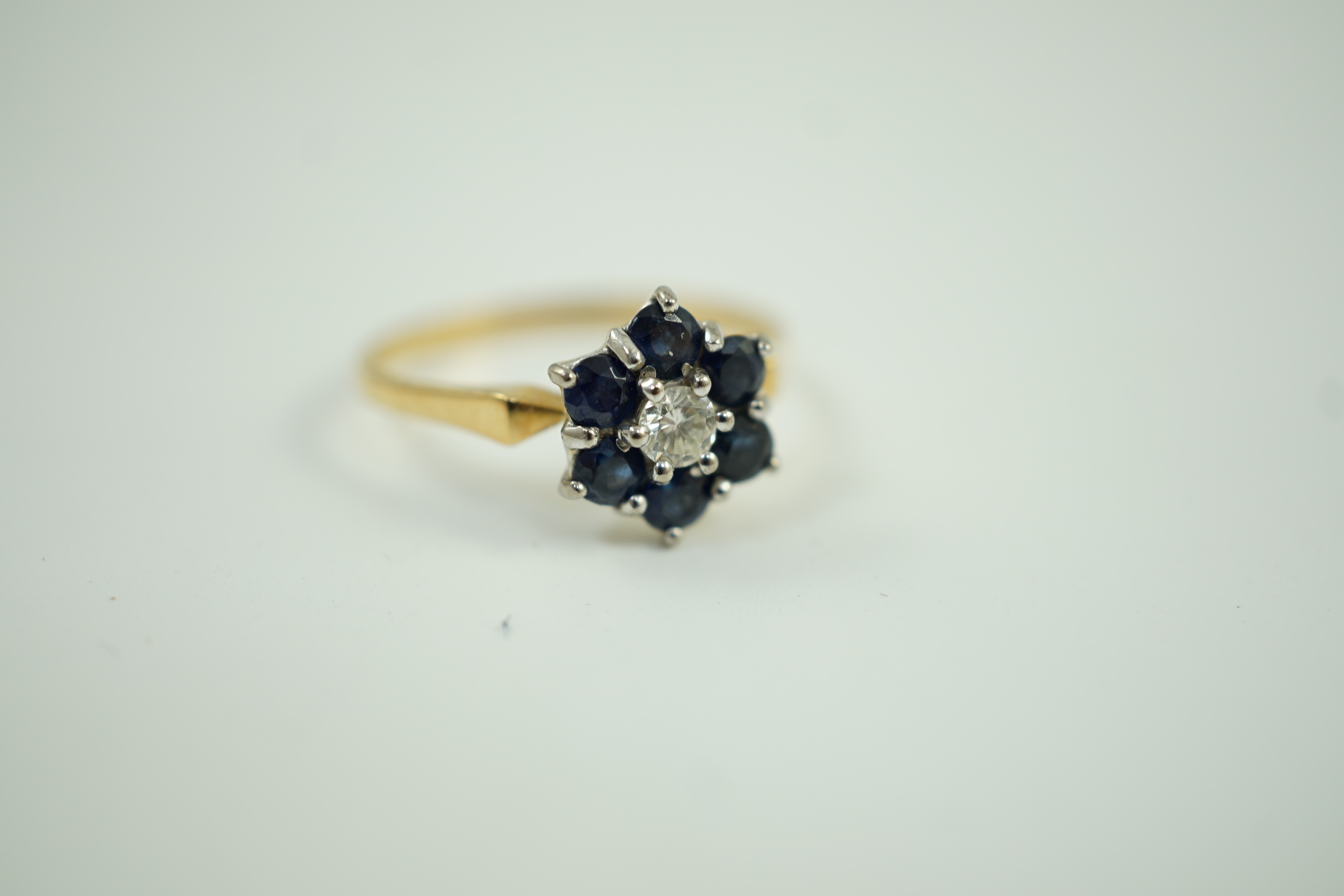 A modern 18ct gold, sapphire and diamond cluster set ring, size Q, gross weight 2.9 grams.